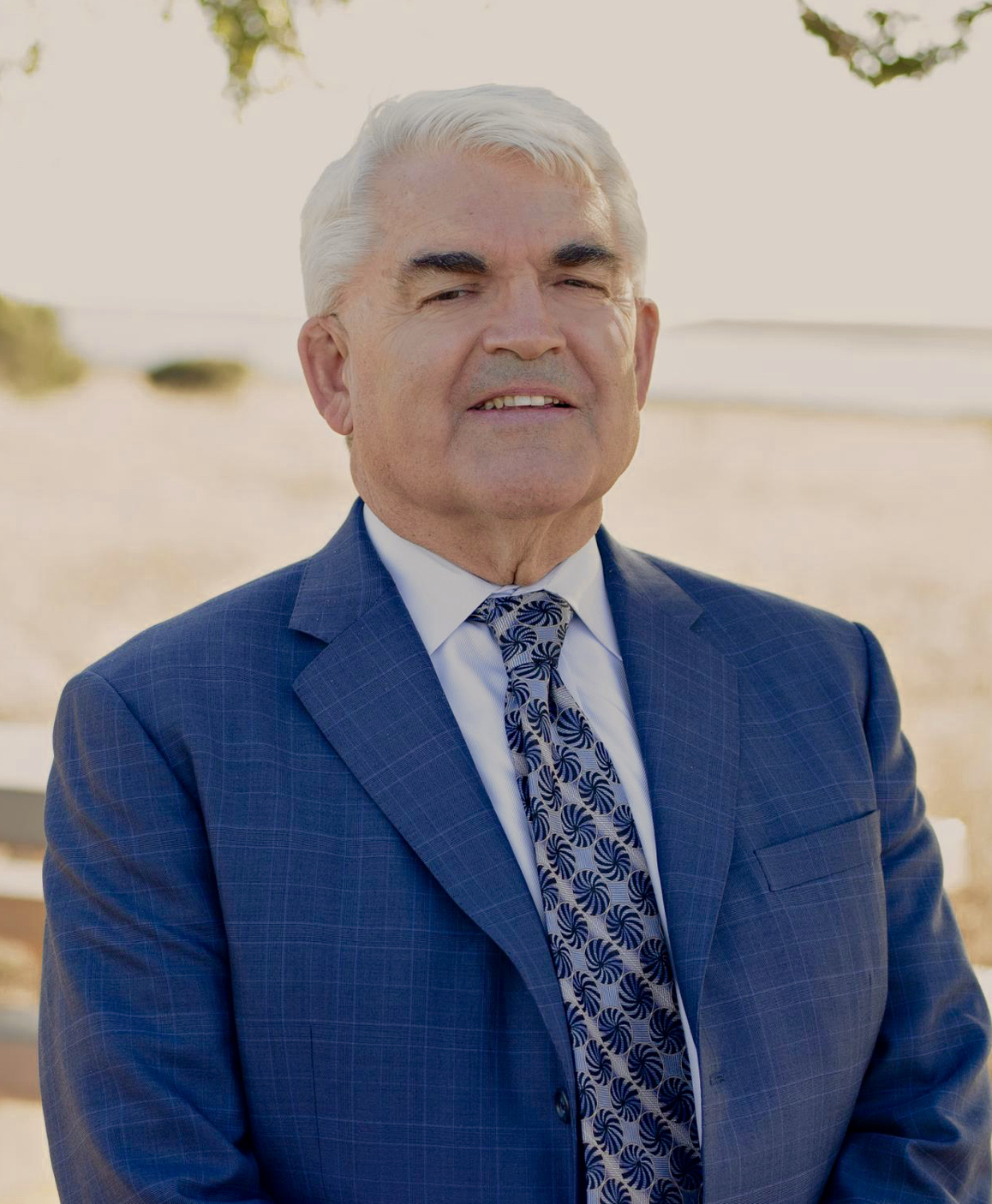 Attorney Bill Ross, wearing a blue suit and patterned tie outdoors.